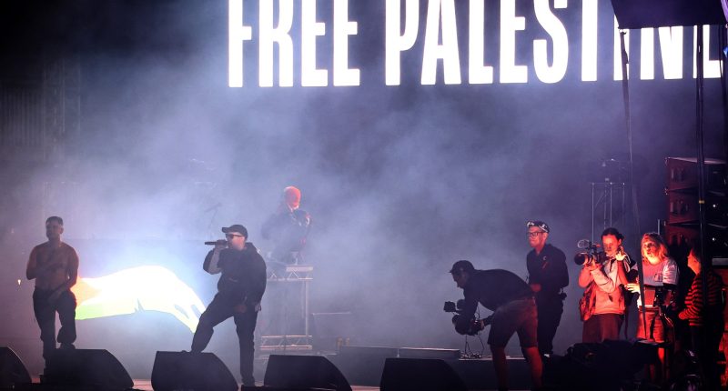 Hip-hop trio Kneecap say cops ‘trying to silence them’ at first major gig since Liam O’Hanna charged with terror offence