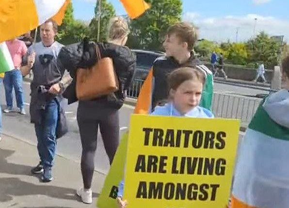 One little girl was seen holding a large sign that read: 'TRAITORS ARE LIVING AMONGST US'