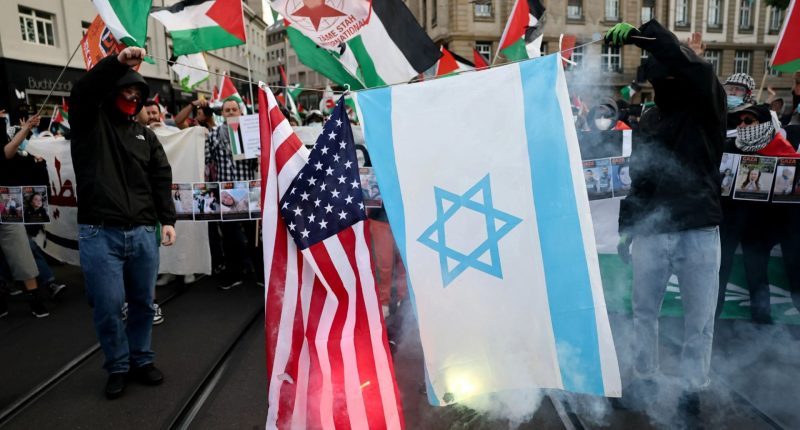 Pro-Palestine protesters in Basel burn Israeli flag as act who survived terror attack performs in Eurovision