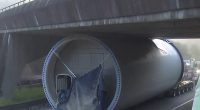 The enormous wind turbine part is jammed under the bridge, causing major disruptions