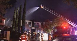 About 30 firefighters worked to extinguish the blaze which engulfed the townhouse (pictured)