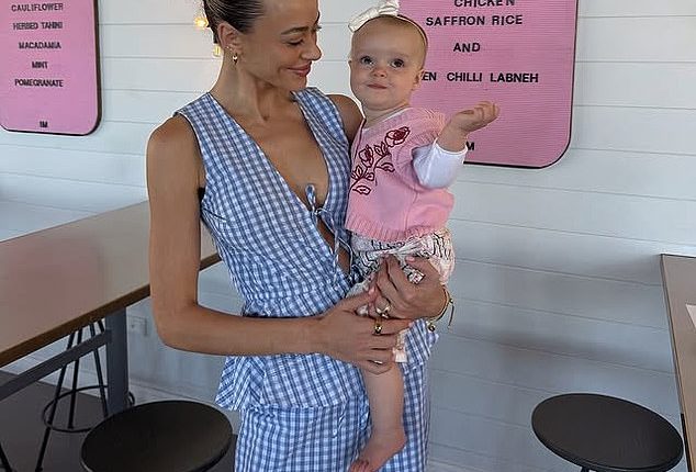 Em Davies (pictured with Isla Sue) was stranded in an airport for four hours while travelling on her own with her nine-month-old baby for the first time