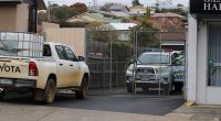 The body of a homeless man was found in an industrial bin behind Salvos Stores Bellerive. Pictured are police at the scene