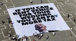 Amazon boss Jeff Bezos and bride to be Lauren Sanchez 's have been forced to change one of the venues for their $48 million Venice wedding because of 'rising global tensions' it was claimed today. Pictured: A large banner against Amazon founder Jeff Bezos lies on the ground