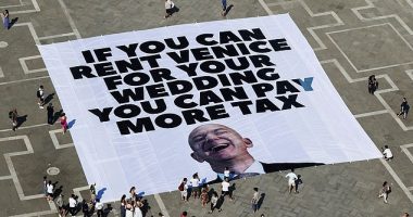 Amazon boss Jeff Bezos and bride to be Lauren Sanchez 's have been forced to change one of the venues for their $48 million Venice wedding because of 'rising global tensions' it was claimed today. Pictured: A large banner against Amazon founder Jeff Bezos lies on the ground