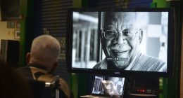 Jim Guines watching a retrospective of his life 10 years ago at a celebration of his legacy at Flagler Palm Coast High School. (© FlaglerLive)
