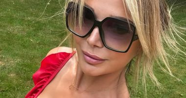 Lizzie Cundy looks stunning as she soaks up the sun in plunging red swimsuit