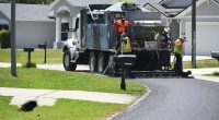 A crew applying an asphalt sealant on a P-Section street in April. The sealant is a lower-grade, cheaper alternative to repaving. It is intended to extend the life of a street
