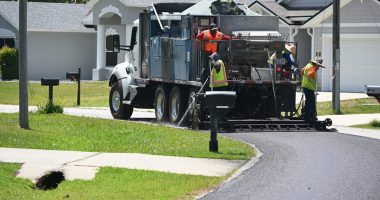 A crew applying an asphalt sealant on a P-Section street in April. The sealant is a lower-grade, cheaper alternative to repaving. It is intended to extend the life of a street