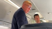 Peter Dutton (pictured) was seen loading his luggage in the overhead locker before spotting the camera
