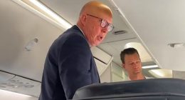 Peter Dutton (pictured) was seen loading his luggage in the overhead locker before spotting the camera