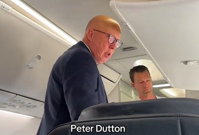 Peter Dutton (pictured) was seen loading his luggage in the overhead locker before spotting the camera