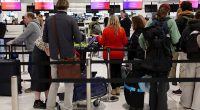 An urgent travel warning has been issued for Australians travelling to or transiting through Qatar (pictured, travellers at Sydney International Airport)