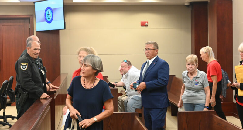 Palm Coast Mayor Mike Norris walking into court among supporters last week. Less than an hour later, he would walk out in defeat. (© FlaglerLive)