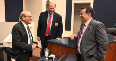 Thursday night trinity at the Flagler County Commission. From left, County Attorney Al Hadeed, who is retiring in a few days, Commissioner Greg Hansen, and newly chosen County Attorney Michael Rodriguez, moments after the commission