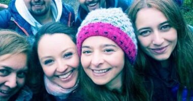 Upon first glance, it may seem as though there are group of six people - four women and two men - who are posing for a selfie while trekking in a forest - but on further inspection, there appears to be a spirit lurking in the picture