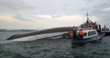 Relief personnel gathered around a capsized tourist boat, which had been carrying 53 passengers when it capsized - of these at least 27 are believed to have died