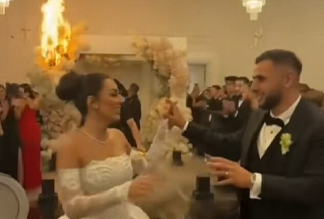 The couple's first dance quickly descended into chaos as indoor fireworks and pyrotechnics erupted near a floral archway and lit the pricey blooms on fire (pictured)