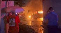 Firefighters worked through the early hours of Sunday morning to bring the fire under control (pictured, locals watch on as fire crews fight the blaze)