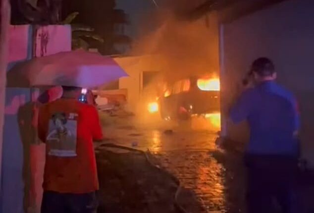 Firefighters worked through the early hours of Sunday morning to bring the fire under control (pictured, locals watch on as fire crews fight the blaze)